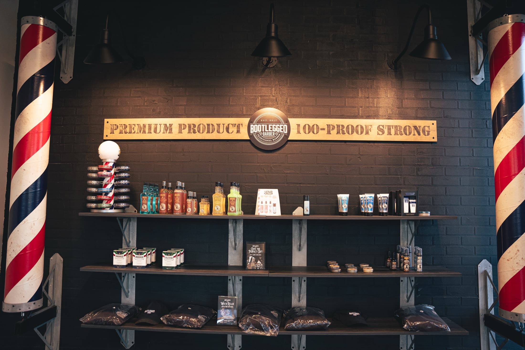 Premium product wall flanked by two full-size barber poles at the Herriman shop
